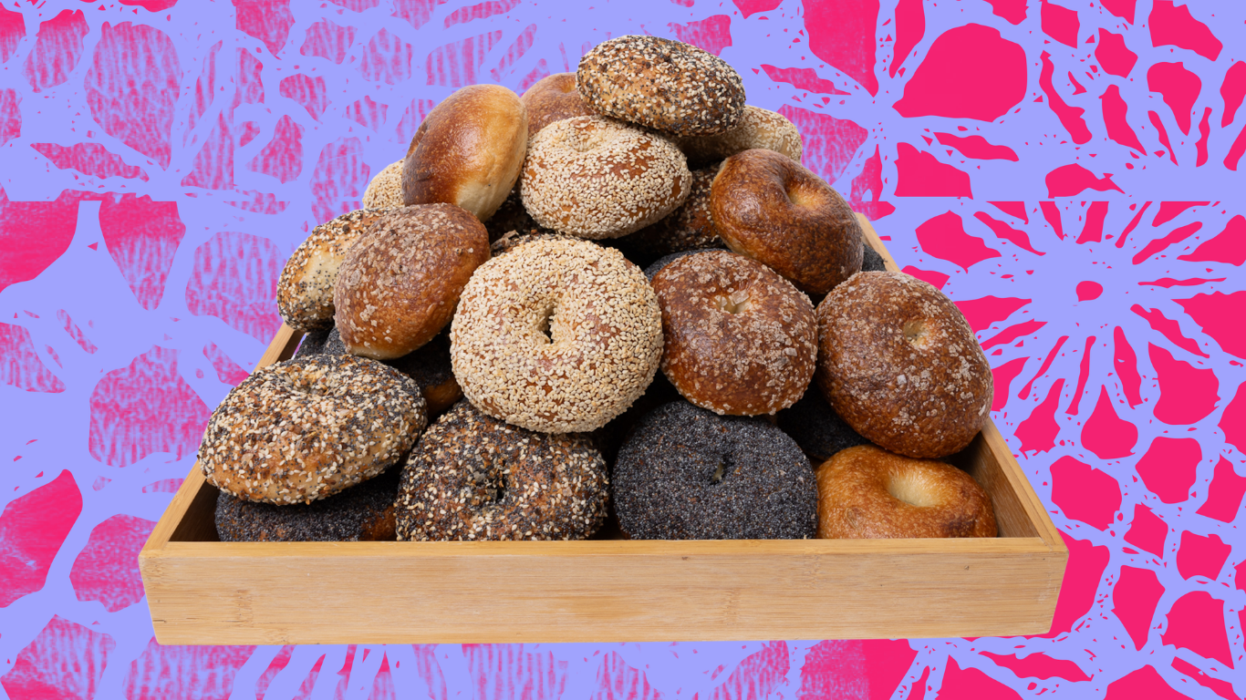A box is filled with bagels stacked in a pyramid.