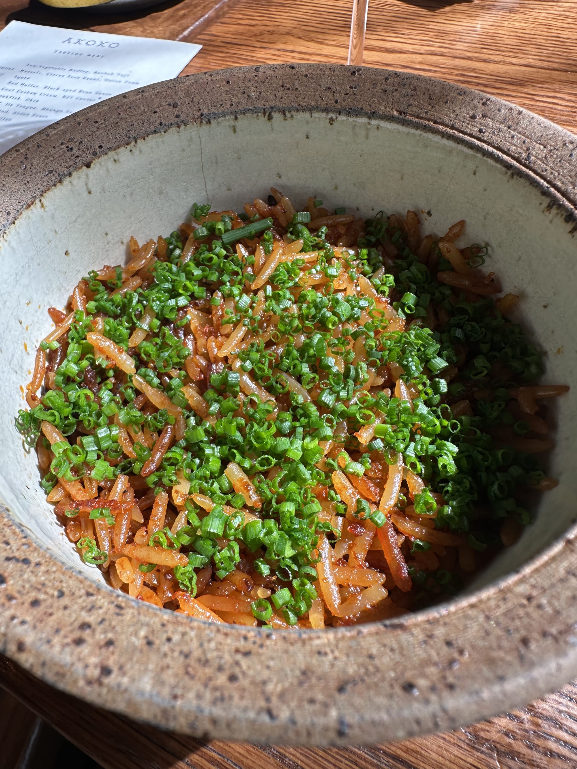 A bowl of jollof rice at Akoko, garnished with chives