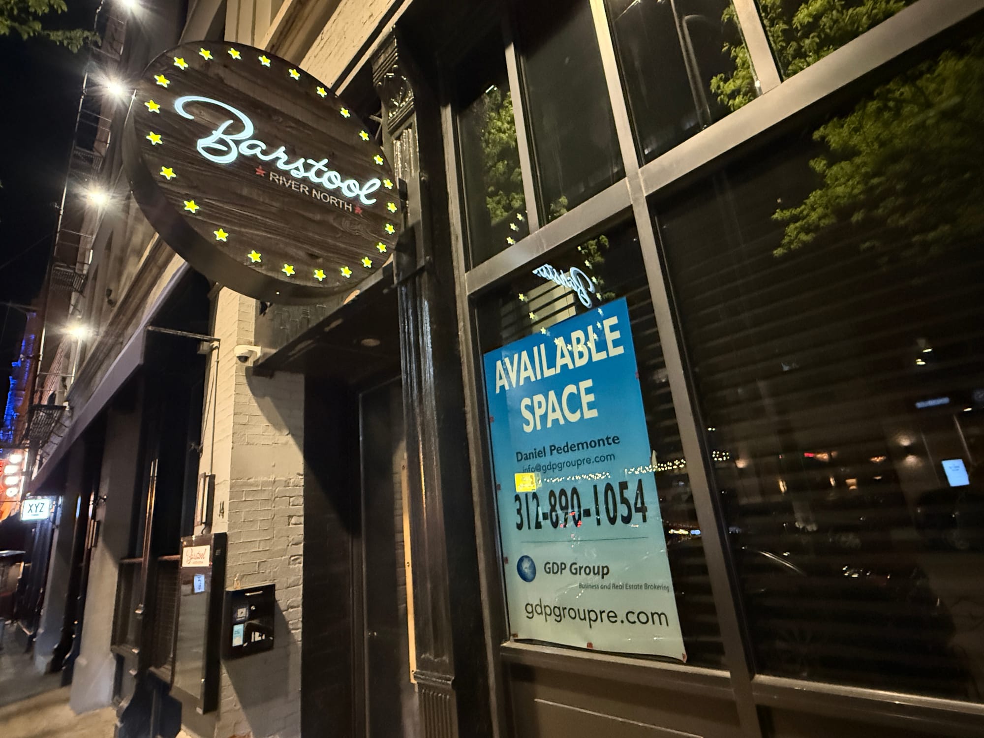 The exterior of the Barstool bar in Chicago with an "available space" sign up in the window.