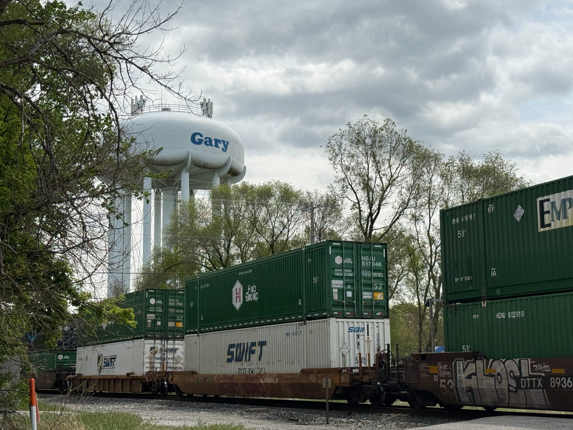 Train cars passing by the Gary water tower.