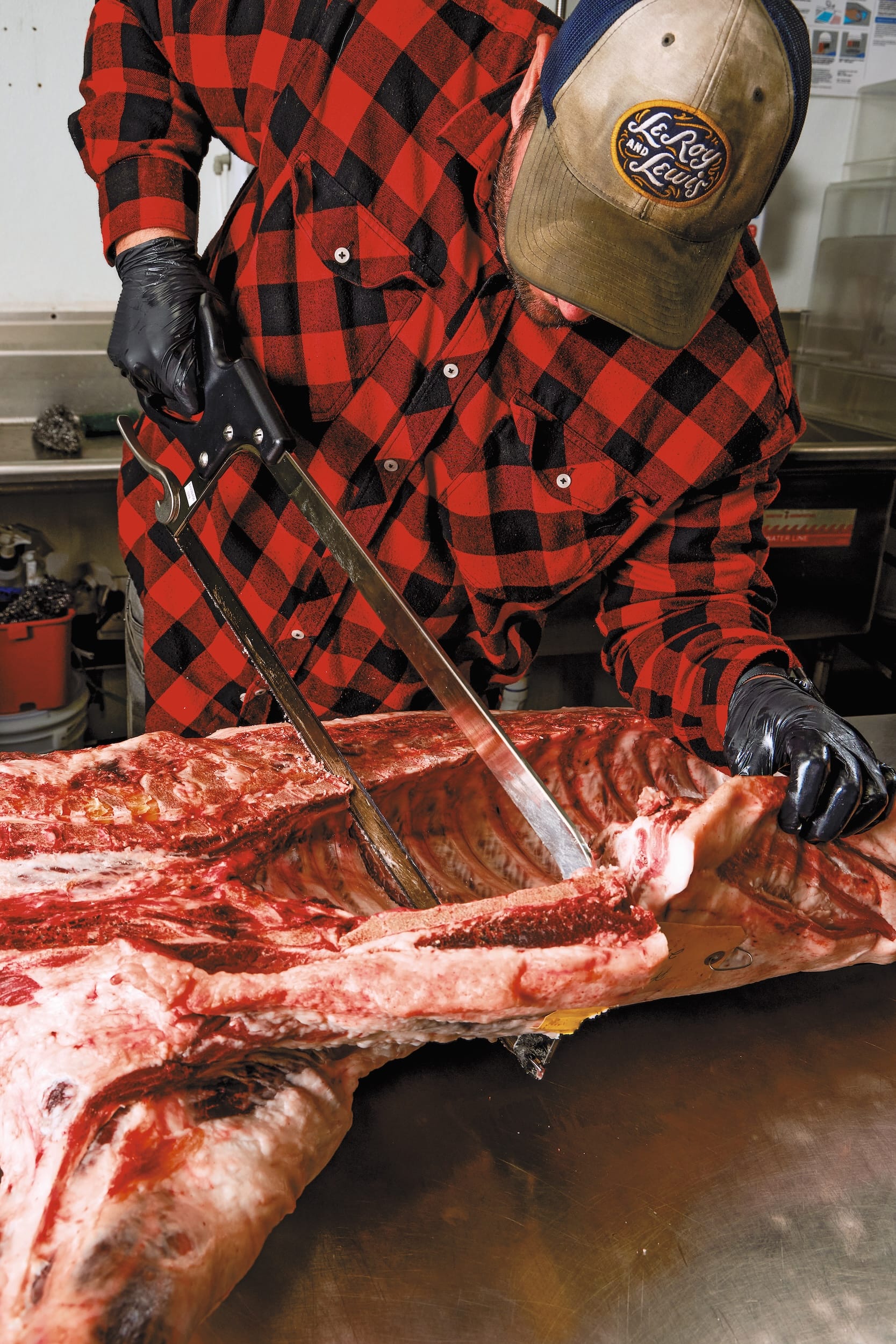 A man cuts into the carcass of a cow.