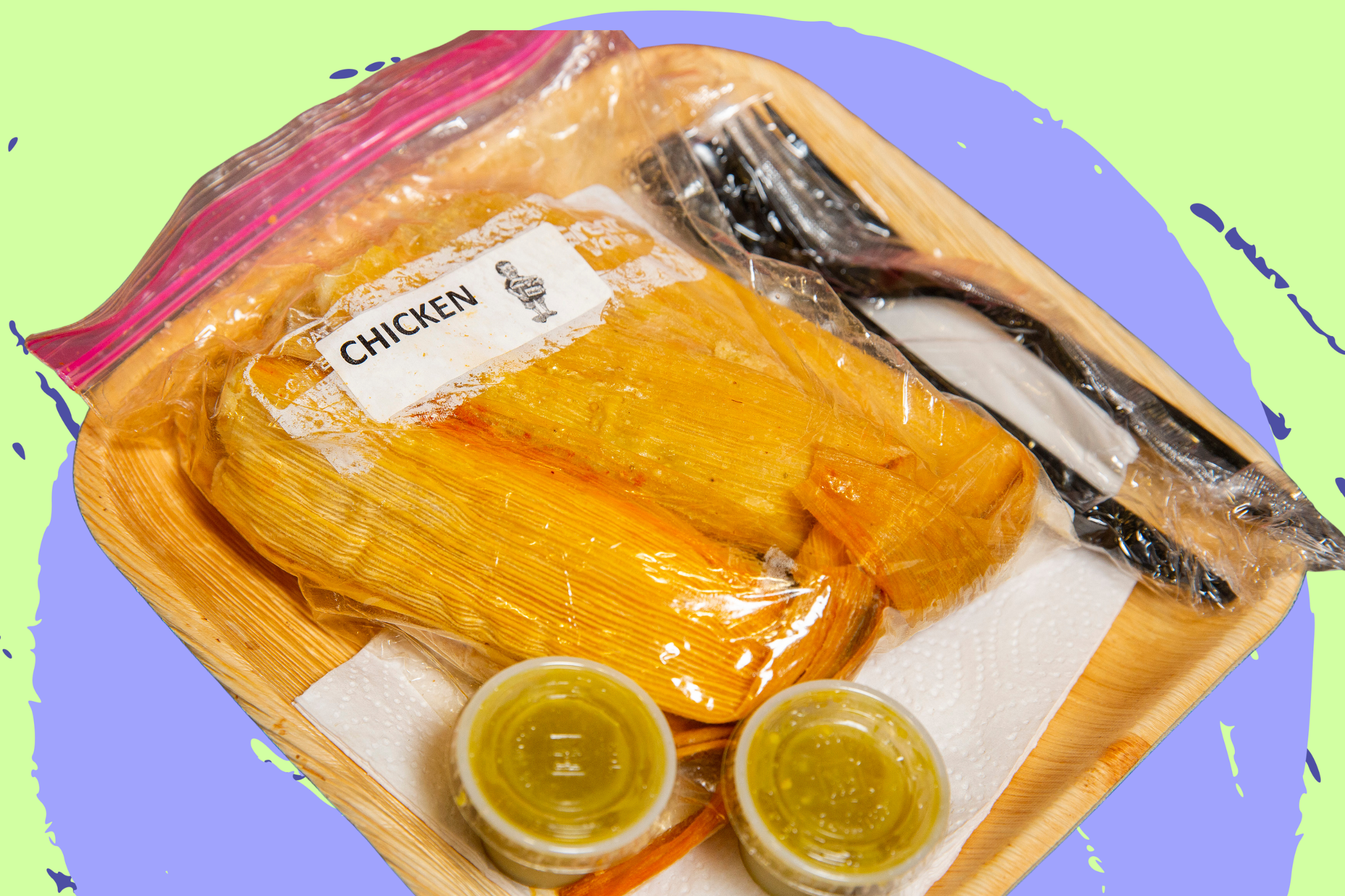 A bamboo square plate with a plastic bag of tamales in their husk with two ramekins of green salsa.