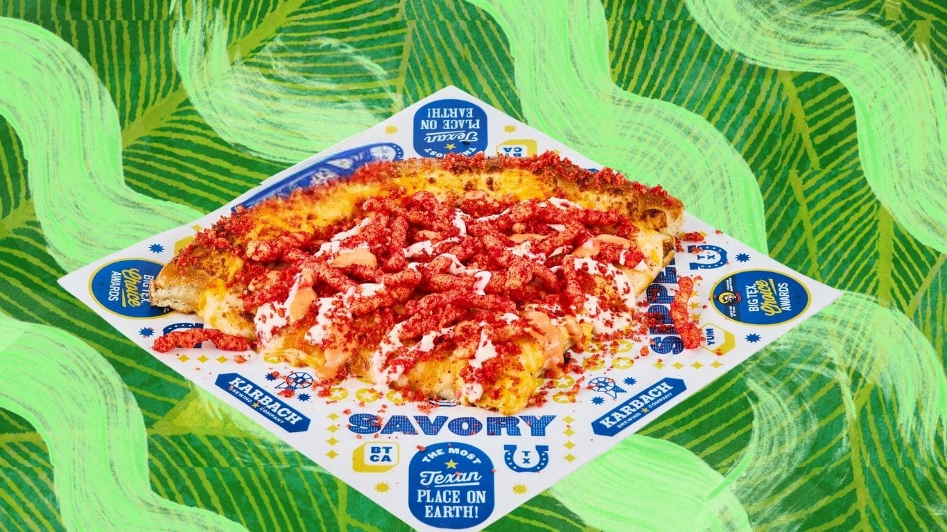 A slice of pizza is covered in melted cheese and Flamin' Hot Cheetos.