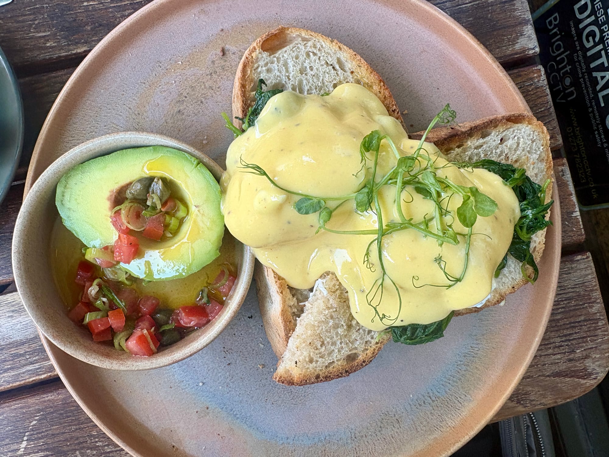 Les oeufs Florentine on sourdough, smothered in hollandaise sauce, with a side of avocado.