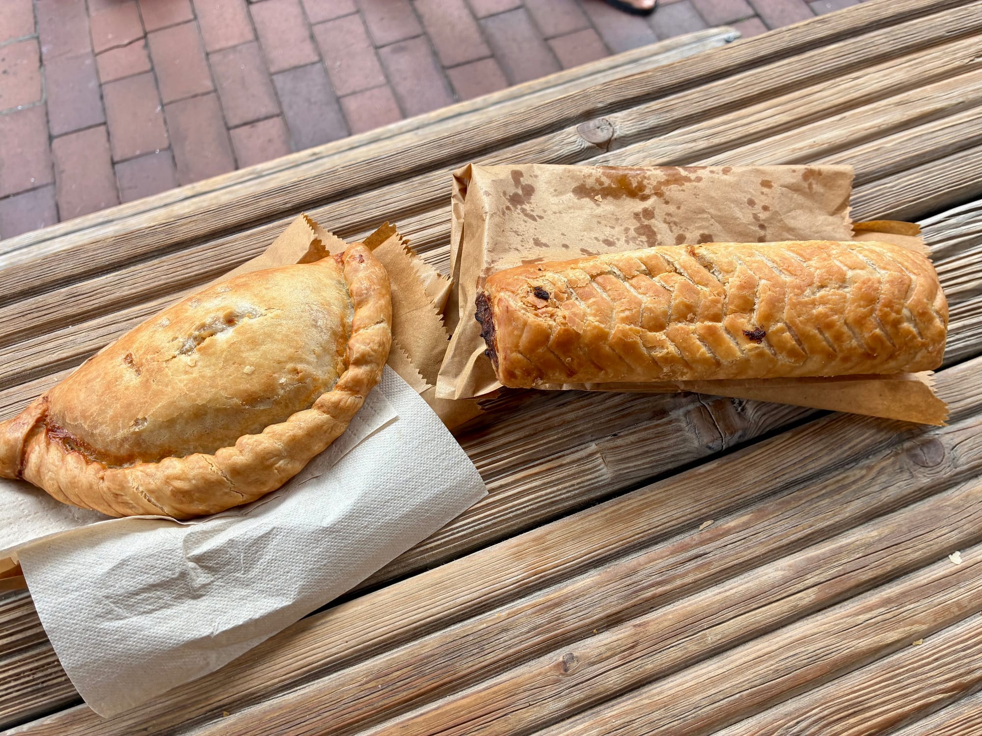 On the left is a hand pie stuffed with cheese and onions. On the right is a vegetarian sausage roll.