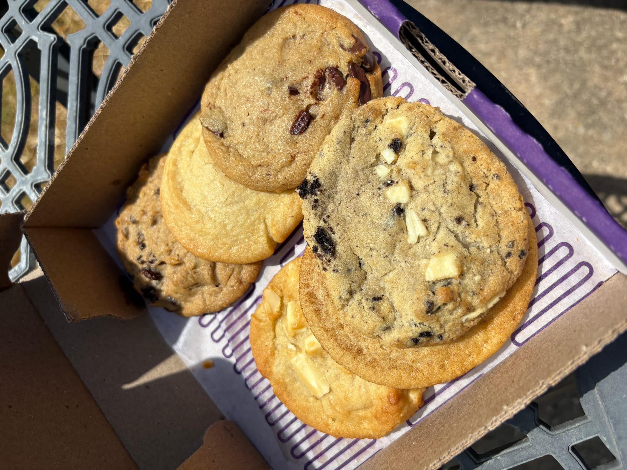 A six-pack of cookies of various types is served in a pizza-style box.