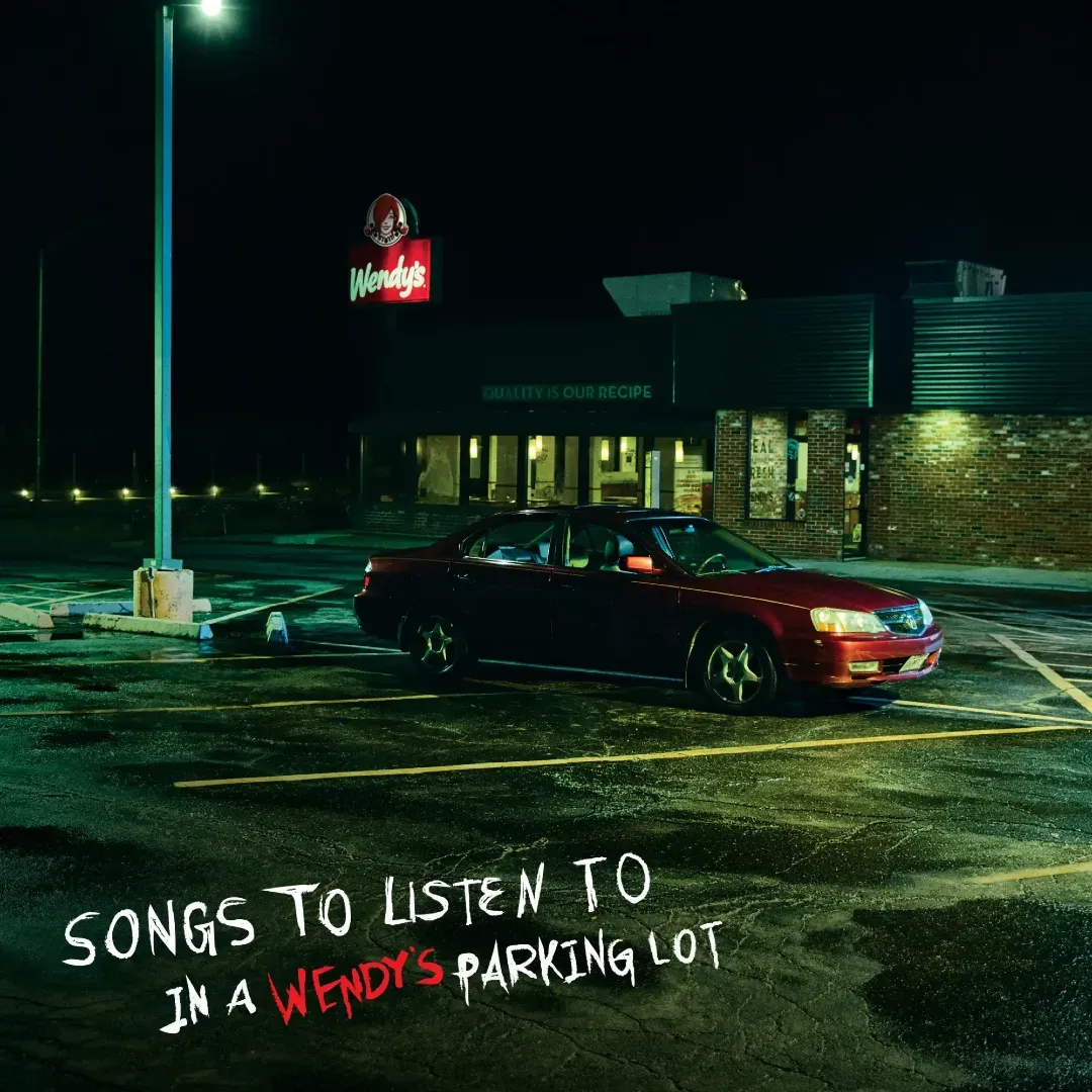 An image of a Wendy's parking lot with a red car parked.