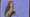 An owl with two orange eyes, from the Hooters logo, on a purple backgrou