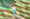 A hand holding a Bomb Pop in front of a green-hued, wavy American flag.