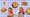 A photo of twins with strawberry emojis covering their faces with beige foods around their heads (pancakes, peanut butter and jelly sandwich, tater tots, chicken nuggets, and quesadillas). 