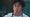 Jeremy Allen White looking at the camera while wearing a white t-shirt and apron.