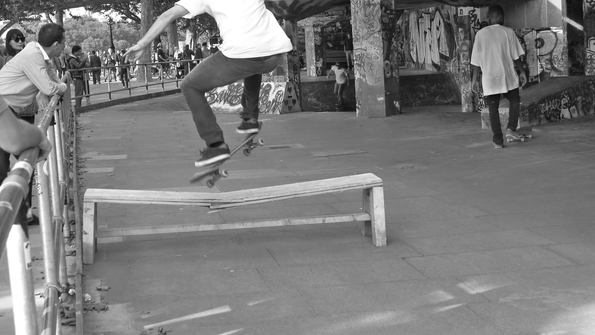 A photo of a skateboarder jumping a bench in London