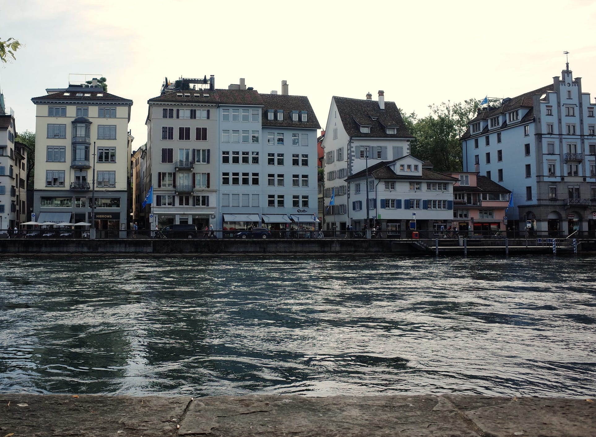 A photograph of the riverside in Zurich with buildings across the river