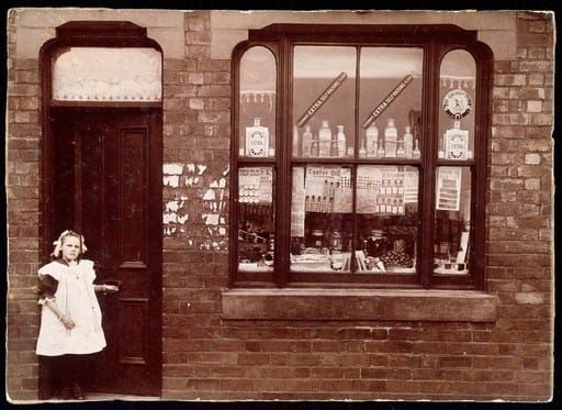 A photo of an old shop in England - A grocer's shop in England: doorway and shop window. Photograph. - Wellcome Collection, United Kingdom - CC BY.