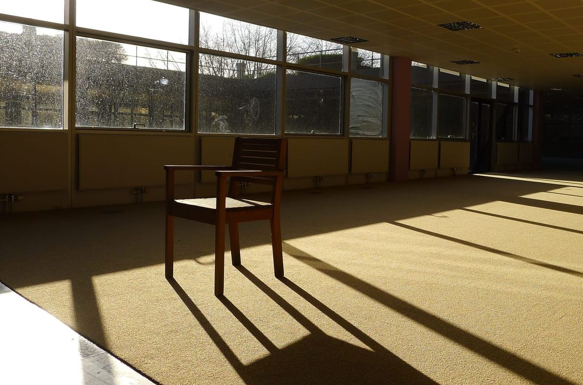 A photo of a lone chair in an empty office space