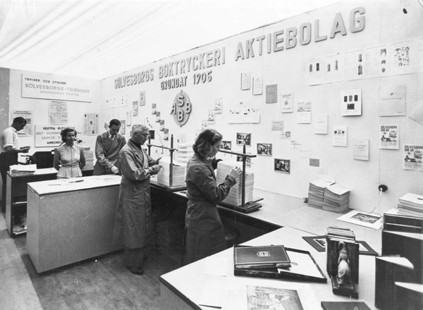 A photo of people in a design and standards lab, printing material.