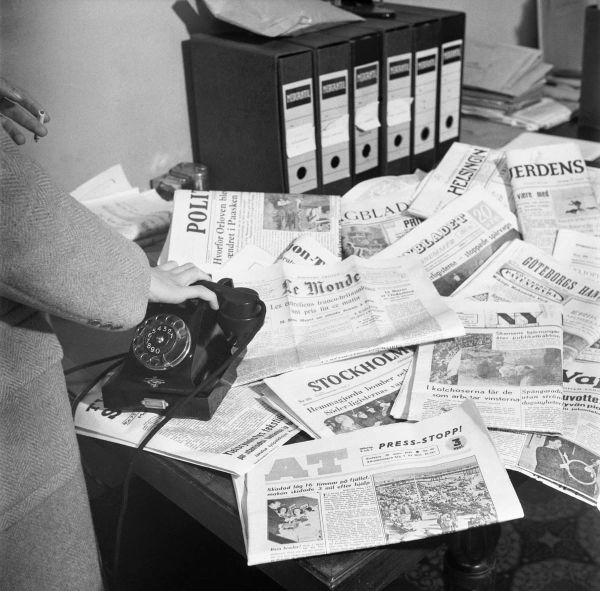 An old photo of newspapers on a desk - source: Foreign newspapers on the newsroom desk by Saarinen, UA - Finnish Heritage Agency, Finland - CC BY.