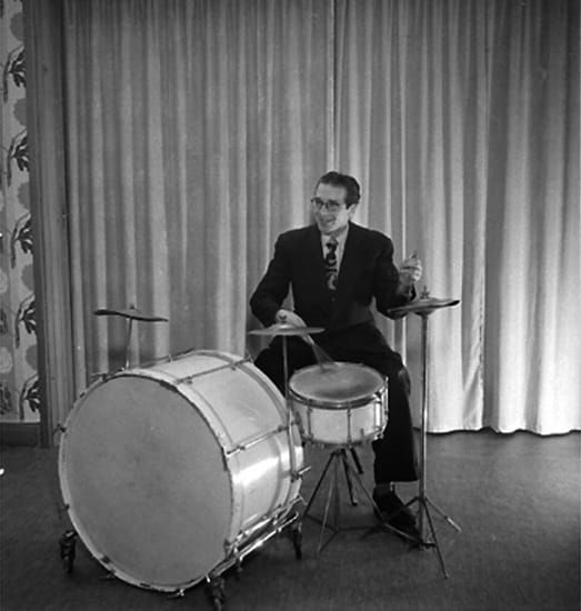 A man playing drums from - Hagströms orkester, en man med musikinstrument (trummor). by Borg, Knut - Örebro County Museum, Sweden - Public Domain.