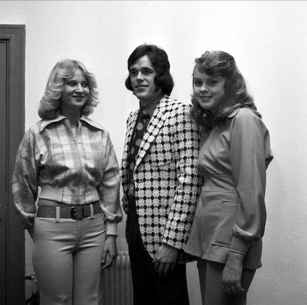 A 1970s fashion show with two women and one man styling clothes