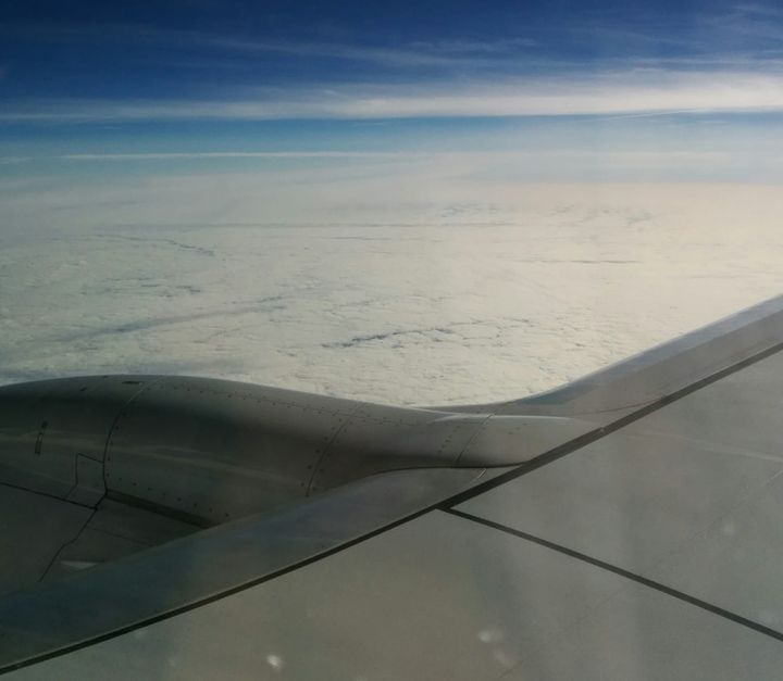 A photo taken out of an airplane window with fluffy clouds