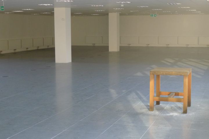 A photo of a stool in an abandoned office space