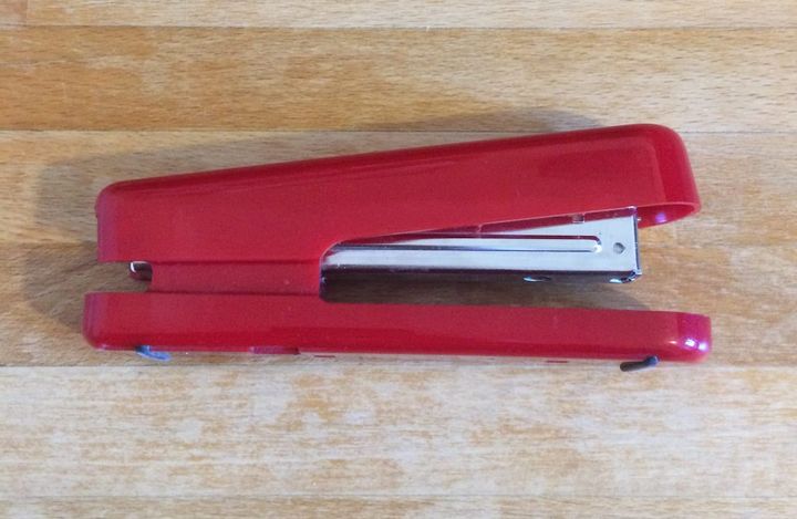 A photo of a red stapler on a desk
