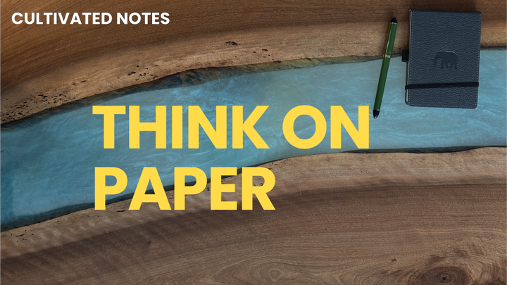 A photo of a desk with text overlaid - think on paper