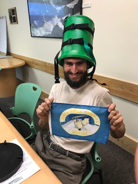 Climber Corneliu Turturica displaying his full pack out flag and demonstrating an unusual use for a clean mountain can.  Photo courtesy of Walter Harper Talkeetna Ranger Station.