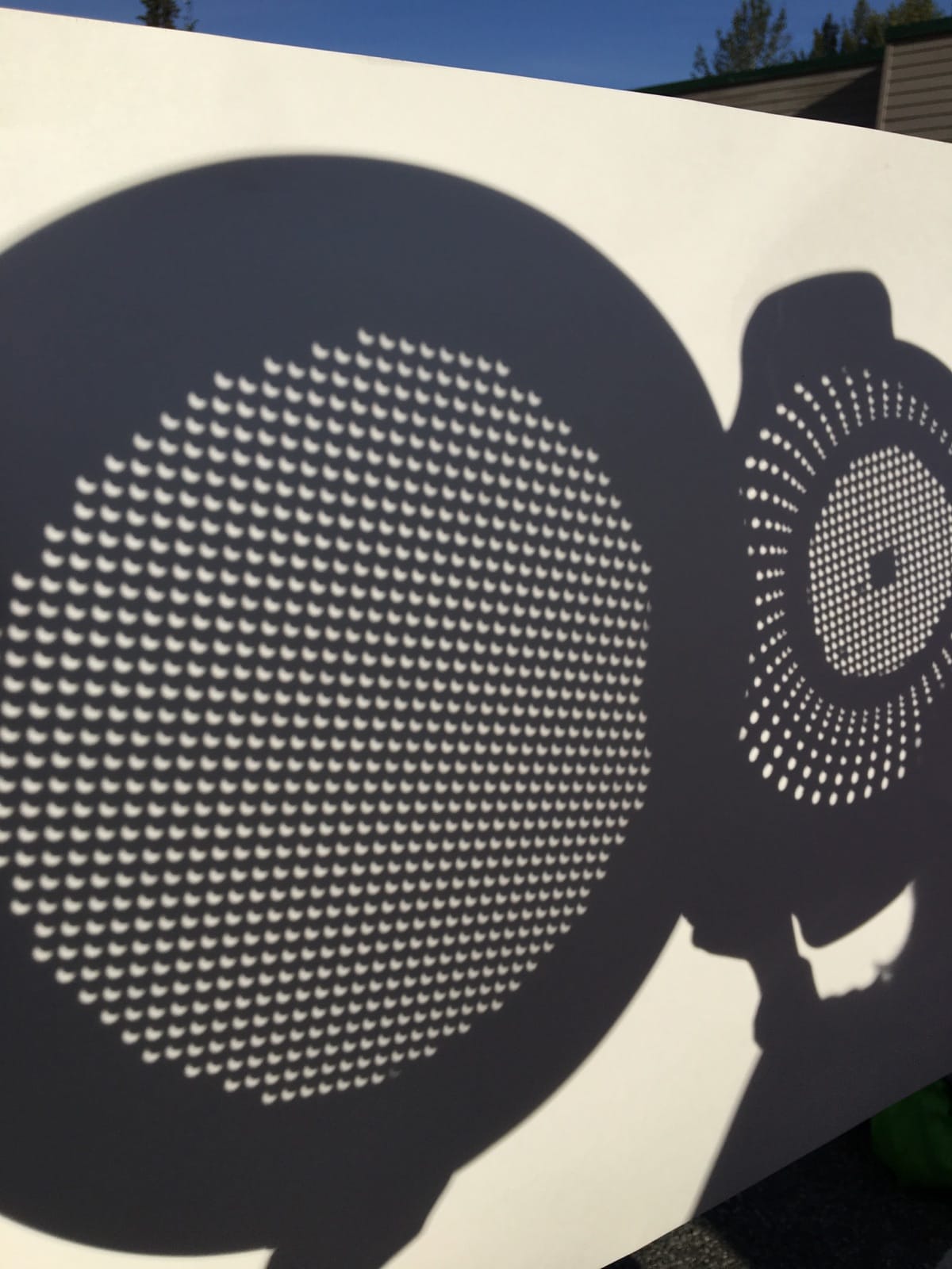 Monday's eclipse viewed through colanders. Note the partially obscured disk of the sun. Photo: Katie Writer - KTNA
