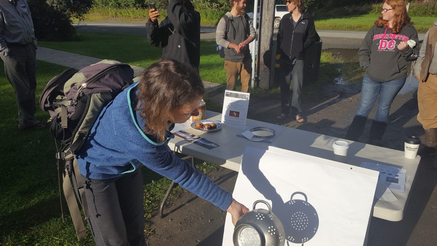 Sarah Kehoe uses a colander to indirectly view Monday's eclipse. Photo - Phillip Manning - KTNA