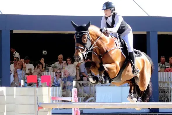 Anastasia Nielsen monta a ESI Rocky sobre un obstáculo durante el Gran Premio de Saint-Tropez, con público en la tribuna.