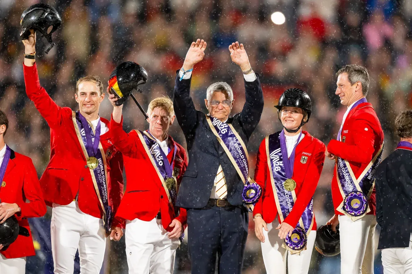 El equipo alemán de Salto celebra con sus medallas de oro bajo la lluvia en el Mundial de Aachen 2026.