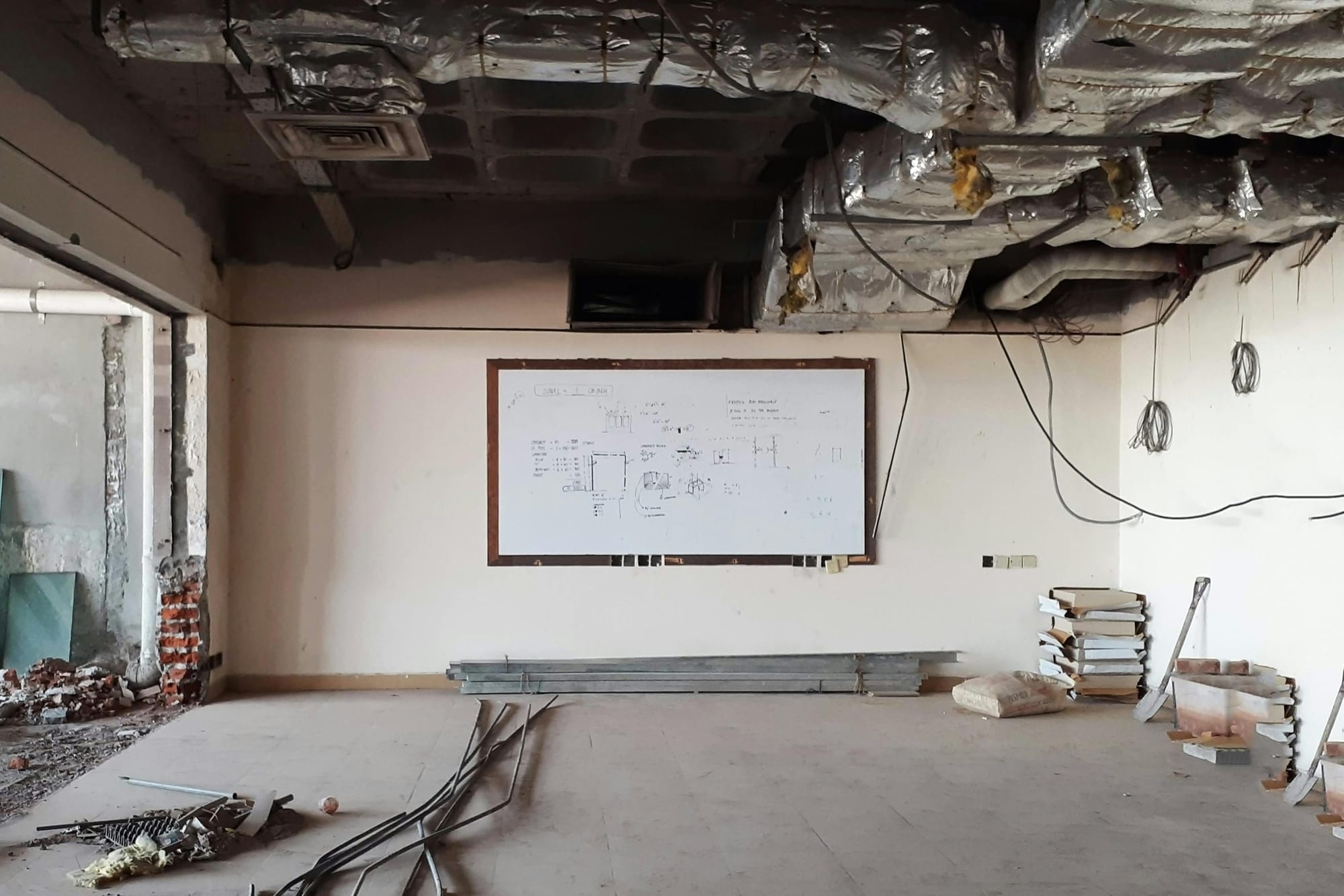 An unfinished room with exposed ceiling insulation and ductwork. 