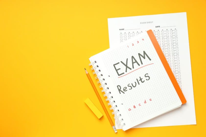 Exam results concept featuring a study notebook, pencil, and standardized test sheet, representing academic success, student grading, and test preparation.