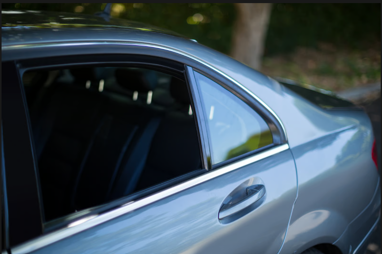 Sleek ceramic window tint film providing sun glare reduction and heat rejection for car passengers.