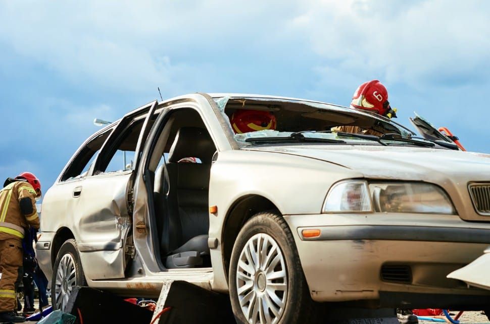 Critical car accident scene with emergency services and vehicle wreckage.