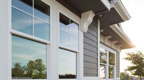 Modern home exterior with large white-trimmed windows and dark gray siding.