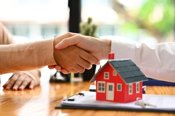 Handshake over a house model