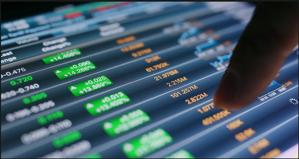 Close-up of a finger tapping a digital screen displaying stock market tickers and positive percentage gains.