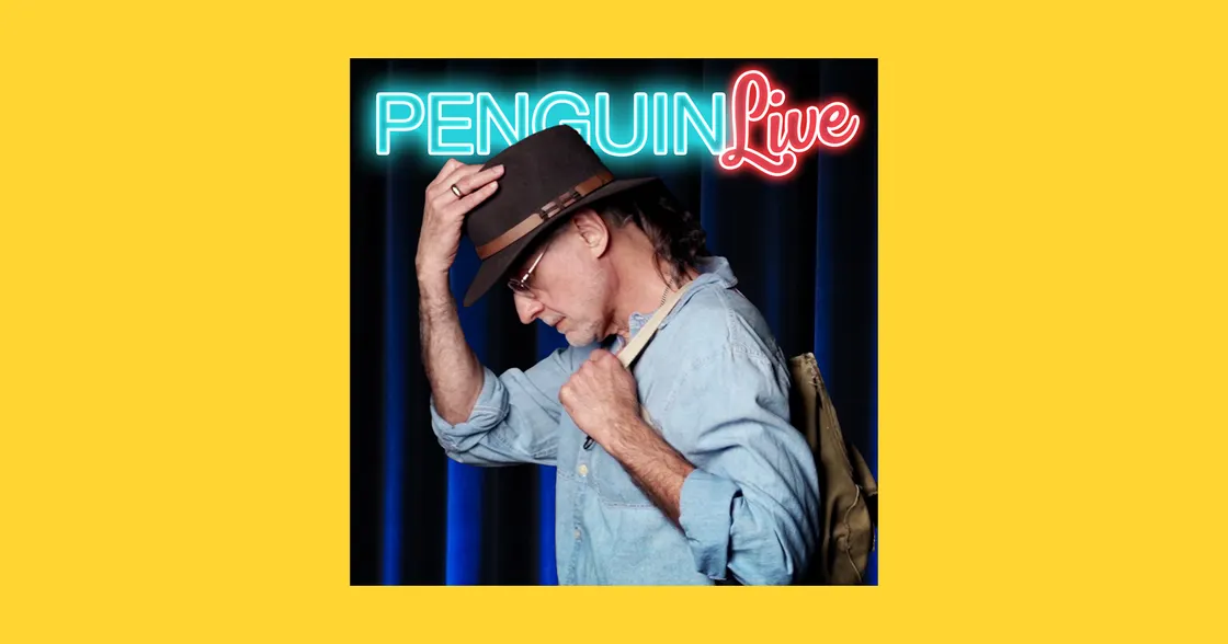 Rick Maue in front of a neon sign reading PENGUIN Live