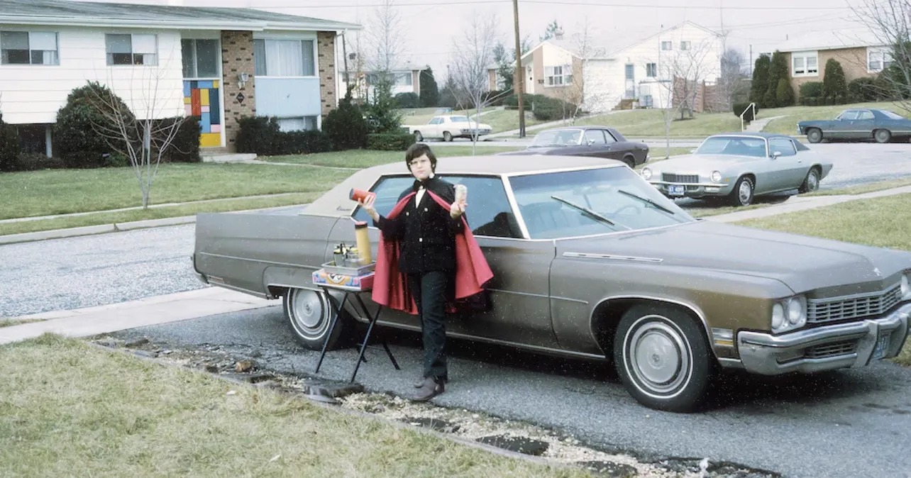 Young Ira Glass as a magician performing magic in a driveway