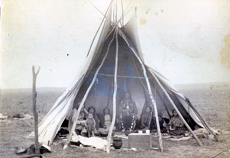 Group of Pawnee. Bayhylle is on the left, holding a child, partially obscured by a lodgepole.