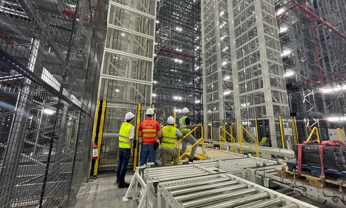 Workers inspect conveyors and storage racks inside the automated warehouse completed by Körber in Southeast Asia.