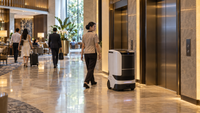 Illustrative wheeled service robot beside lifts in an unbranded hotel lobby