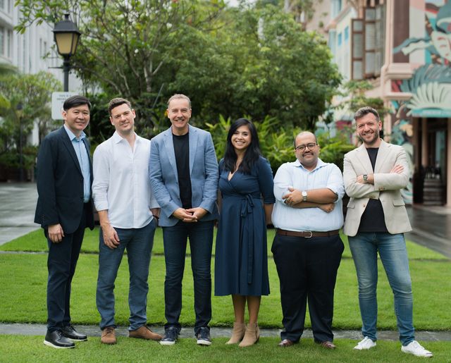 100x100 Partner Group standing outdoors in Singapore for the Fund II announcement.