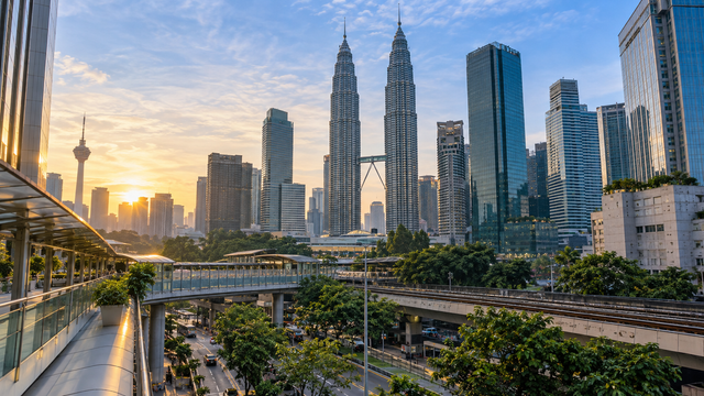 Kuala Lumpur’s central business district at morning, with elevated transit, pedestrian routes and city greenery.