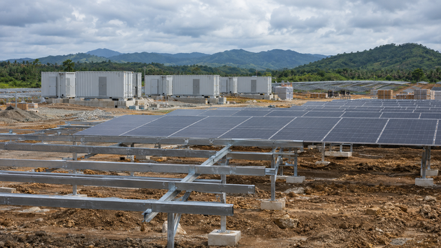 Illustrative solar-panel and battery-storage construction scene in the Philippines; not the Palauig project.
