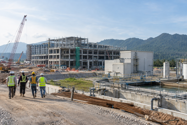Illustrative industrial construction site with a production building, utilities and wastewater works in Malaysia