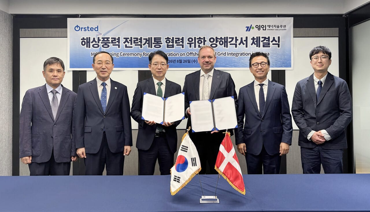 Officials from both companies are taking a group commemorative photo at the signing ceremony.