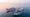 Illustrative image: Korean coastal fishing boats with an offshore wind farm on the horizon